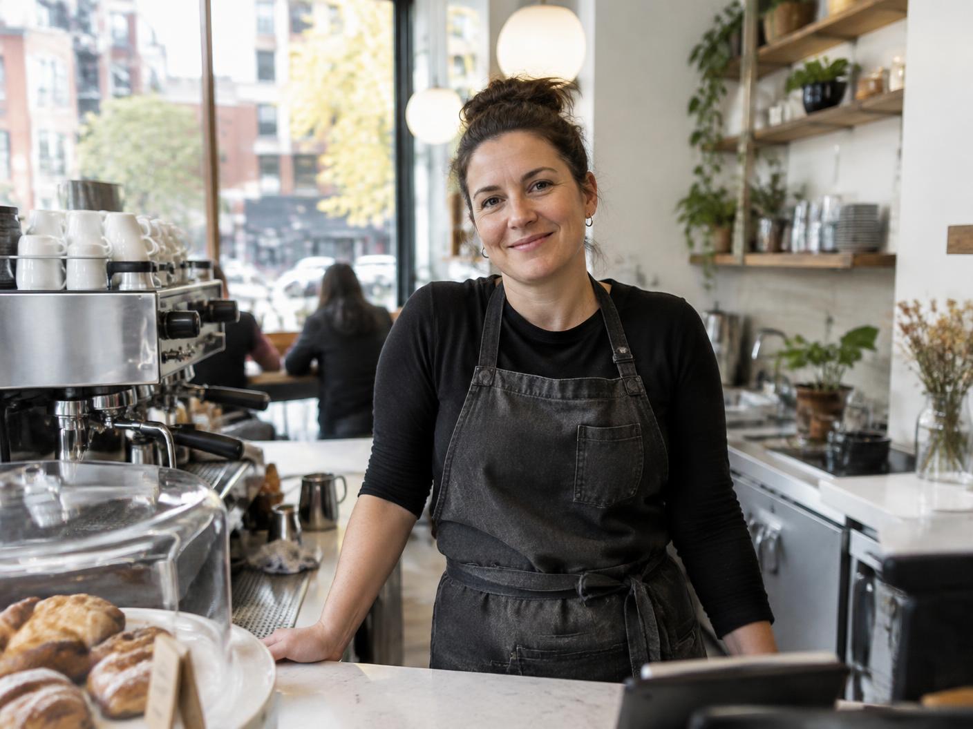 Café owner standing at her counter in a bright contemporary café
